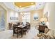 Bright dining room with tray ceilings, elegant chandelier, and decorative table setting at 10953 Bullrush Dr, Venice, FL 34293