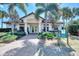 Charming golf shop entrance with brick path, lush landscaping, and towering palms at Sarasota National Golf Club at 10953 Bullrush Dr, Venice, FL 34293