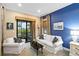 Bright living room featuring comfortable seating, natural light, and views of the outdoor patio and golf course at 10953 Bullrush Dr, Venice, FL 34293