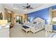 Spacious main bedroom with tray ceiling, sitting area, blue accent wall, and a king-sized bed at 10953 Bullrush Dr, Venice, FL 34293