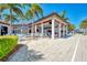 View of the outdoor dining area and pool featuring tables, chairs, and palm trees under a bright, sunny sky at 10953 Bullrush Dr, Venice, FL 34293