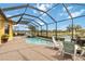 Screened-in pool area featuring a water feature, brick pavers, and comfortable seating overlooking a serene water view at 10953 Bullrush Dr, Venice, FL 34293