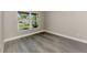Bright, empty bedroom features hardwood floors, baseboard trim, and a large window overlooking a sunny yard at 1183 Cedar Ave, Englewood, FL 34223