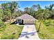 Beautiful single-Gathering home with a well-manicured lawn, mature palm trees, and a concrete driveway leading to an attached garage at 1183 Cedar Ave, Englewood, FL 34223