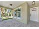 Close-up view of the covered front porch showcasing stone pillars, lighting, and a decorative front door at 1183 Cedar Ave, Englewood, FL 34223
