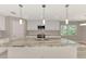 Elegant kitchen showcasing a large island with marble countertop, pendant lights, and stainless steel appliances at 1183 Cedar Ave, Englewood, FL 34223