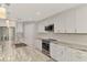 A beautifully updated kitchen with stainless steel appliances, marble countertops, and sleek white cabinets and drawers at 1183 Cedar Ave, Englewood, FL 34223