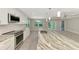 Sunlit open-concept kitchen showcases stainless steel appliances, marble countertops, and views of the living space at 1183 Cedar Ave, Englewood, FL 34223