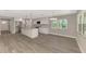 Bright kitchen with white cabinets, granite countertops, stainless appliances, and gray wood flooring at 1183 Cedar Ave, Englewood, FL 34223
