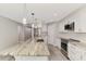 Bright kitchen boasts stainless steel appliances, white cabinetry, and a stunning marble island with pendant lighting at 1183 Cedar Ave, Englewood, FL 34223