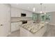 An open kitchen with a marble island, stainless steel appliances, and ample natural light from surrounding windows at 1183 Cedar Ave, Englewood, FL 34223