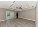 Bright, airy living room featuring tray ceiling, ceiling fan, and modern gray wood flooring at 1183 Cedar Ave, Englewood, FL 34223