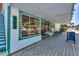 Charming storefront with large windows, featuring an art gallery and outdoor seating on a brick walkway at 1183 Cedar Ave, Englewood, FL 34223