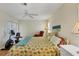 Comfortable bedroom featuring a ceiling fan, bedside lamp, and natural light from the window at 1317 Le Pera Rd, Englewood, FL 34223