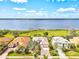 Aerial view showcasing a waterfront home with mature landscaping and a serene lake backdrop at 14026 Royal Pointe Dr, Port Charlotte, FL 33953