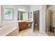 The main bathroom features double sinks, a bathtub, vanity, separate lavatory, and shower with glass doors at 14026 Royal Pointe Dr, Port Charlotte, FL 33953