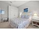 Bright bedroom with ceiling fan, neutral walls and carpet, white trim and doors, and a large painting at 14026 Royal Pointe Dr, Port Charlotte, FL 33953