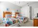 A charming bedroom with two twin beds features neutral walls and carpet, white trim, ceiling fan, and a side table at 14026 Royal Pointe Dr, Port Charlotte, FL 33953