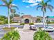 Exterior of the charming clubhouse featuring a porte cochere, tropical landscaping and inviting facade at 14026 Royal Pointe Dr, Port Charlotte, FL 33953