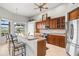The kitchen features warm wood cabinetry, stainless appliances, and a breakfast bar at 14026 Royal Pointe Dr, Port Charlotte, FL 33953