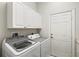 Practical laundry room with a front-loading washer and dryer, complemented by built-in cabinets at 14026 Royal Pointe Dr, Port Charlotte, FL 33953