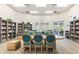 Well-lit library featuring rows of books, comfortable chairs, and a large table for studying or gathering at 14026 Royal Pointe Dr, Port Charlotte, FL 33953