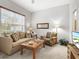 Comfortable living room featuring a plush sofa, patterned armchair, and sunlit window at 14026 Royal Pointe Dr, Port Charlotte, FL 33953