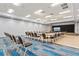 Large meeting room with modern lighting, tables, chairs, and a projection screen for presentations at 14026 Royal Pointe Dr, Port Charlotte, FL 33953
