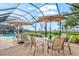Backyard patio with a table and chairs, lounge chairs, and scenic views of the lake at 14026 Royal Pointe Dr, Port Charlotte, FL 33953