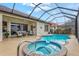 A screened-in pool area with a spa, and comfortable outdoor furniture for relaxation and enjoyment at 14026 Royal Pointe Dr, Port Charlotte, FL 33953