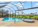Screened-in pool area with a luxurious swimming pool and spa, surrounded by lush landscaping and water views at 14026 Royal Pointe Dr, Port Charlotte, FL 33953
