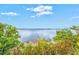 A serene waterfront view with lush greenery and a tranquil beach at 14026 Royal Pointe Dr, Port Charlotte, FL 33953