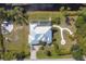 Aerial view of home with screened-in pool and patio, fire pit, and lush landscaping at 14157 Kewanee Ln, Port Charlotte, FL 33981