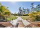 Relaxing backyard view from the deck with lounge chairs and a scenic landscaped pathway at 14157 Kewanee Ln, Port Charlotte, FL 33981