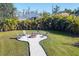 Landscaped backyard with a fire pit and seating, perfect for outdoor entertaining at 14157 Kewanee Ln, Port Charlotte, FL 33981