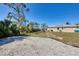 Large backyard with a gravel area, open lawn, and a view of the screened-in lanai at 14157 Kewanee Ln, Port Charlotte, FL 33981