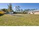 Spacious backyard featuring well-maintained lawn and surrounding greenery offering lots of space for recreation at 14157 Kewanee Ln, Port Charlotte, FL 33981