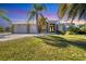 Beautiful single-Gathering home with a three-car garage, well manicured lawn, and elegant entryway at 14157 Kewanee Ln, Port Charlotte, FL 33981