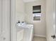 Bright laundry room with washer, dryer, and storage shelves at 14157 Kewanee Ln, Port Charlotte, FL 33981