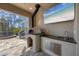 The outdoor kitchen features a granite countertop, a pizza oven, a sink, and stainless steel drawers at 14157 Kewanee Ln, Port Charlotte, FL 33981