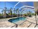 Enclosed pool and jacuzzi with a screened enclosure, brick pavers, and scenic water views at 14157 Kewanee Ln, Port Charlotte, FL 33981