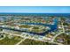 Extensive aerial view of waterfront homes on canals extending to the Gulf, with a neighborhood encircled by mature trees at 14718 San Domingo Blvd, Port Charlotte, FL 33981