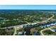 Panoramic view showcasing waterfront homes on canals near a lush, wooded community, extending towards the distant horizon at 14718 San Domingo Blvd, Port Charlotte, FL 33981