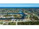 Wide aerial view of waterfront homes on canals leading to the Gulf, with a neighborhood surrounded by mature trees at 14718 San Domingo Blvd, Port Charlotte, FL 33981