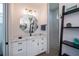 Bright bathroom with white marble countertop, white cabinetry, decorative mirror, and walk-in shower at 14718 San Domingo Blvd, Port Charlotte, FL 33981