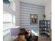 Comfortable den with a leather chair, stylish wallpaper, and natural light from a large window at 14718 San Domingo Blvd, Port Charlotte, FL 33981
