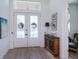 Elegant foyer with a transom window, double doors, stylish console table, and wood-look tile flooring at 14718 San Domingo Blvd, Port Charlotte, FL 33981