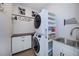 Efficient laundry room with stacked washer/dryer, built-in shelving, and a utility sink at 14718 San Domingo Blvd, Port Charlotte, FL 33981