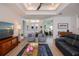 Spacious living room featuring wood-look tile, coffered ceilings, ample seating, and a clear view to the foyer at 14718 San Domingo Blvd, Port Charlotte, FL 33981