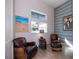 Comfortable living room featuring leather chairs, unique artwork, natural light, and stylish decor at 14718 San Domingo Blvd, Port Charlotte, FL 33981